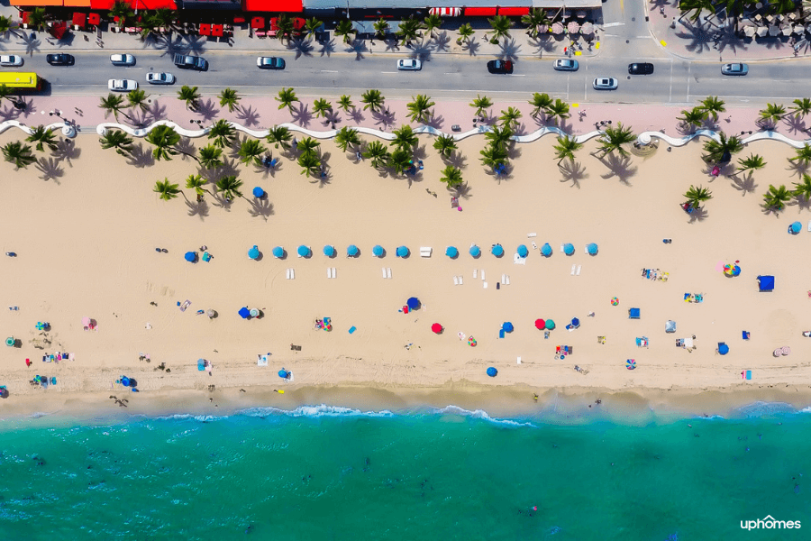 Aerial view of a florida beach with cars driving by and beautiful blue ocean