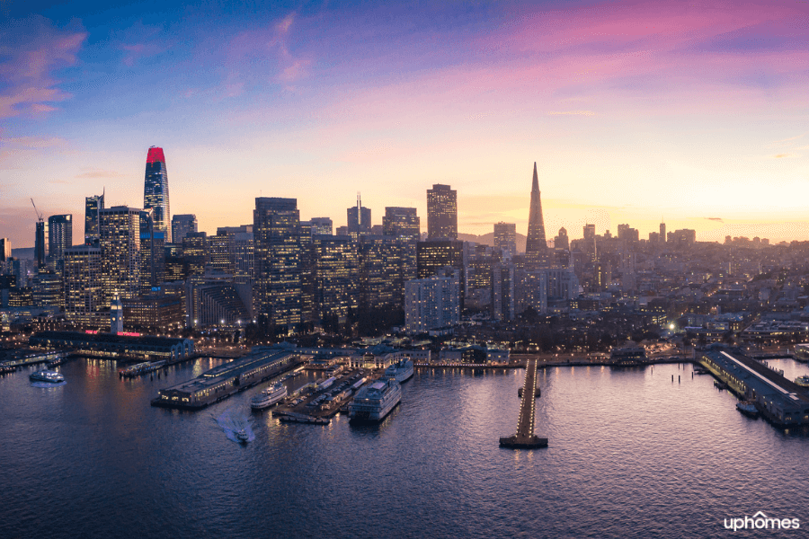 Aerial night view of downtown San Francisco with water, boats, bridge and lots of bright lights