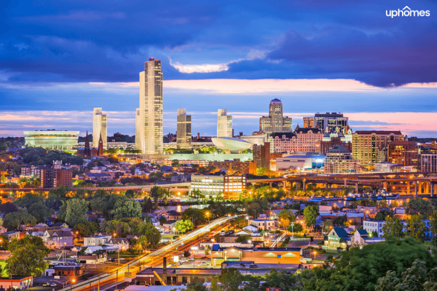 Albany, NY city skyline at night time with the buildings lit up at sunset