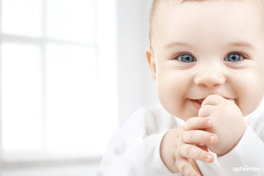 Close up photo of a beautiful baby with blue eyes and big smile - new born baby