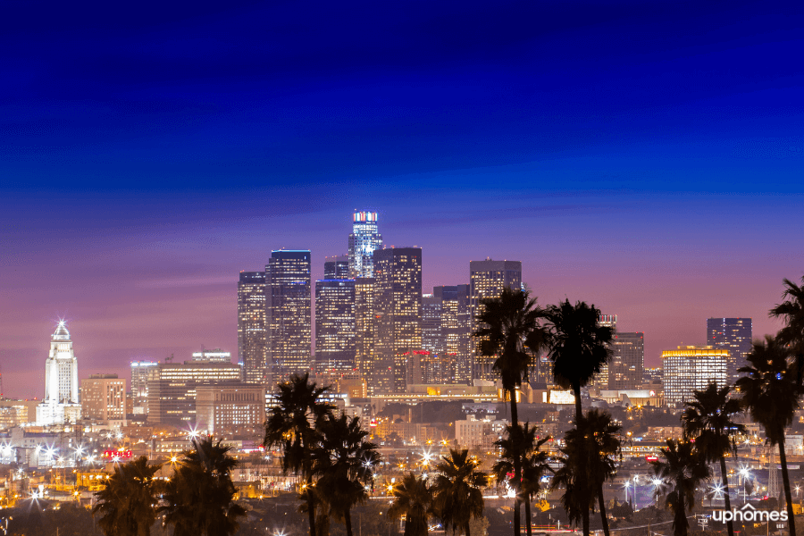 Iconic photo of downtown Los Angeles skyline with the palm trees in the foreground at night time
