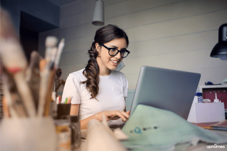 Productive employee working from home with a great home office set up wearing glasses and a big smile on her face