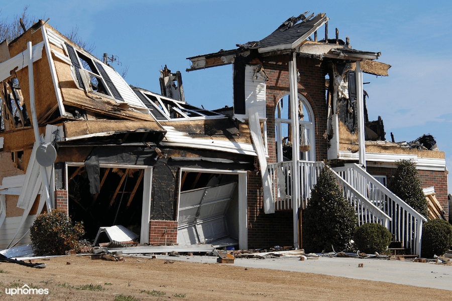 Whole house burned down and falling over with damaged caused by a fire