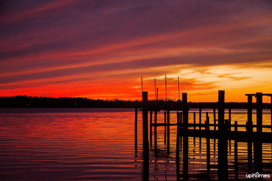 Sunset on the beach in Jacksonville, NC with a beautiful view of the water and pier