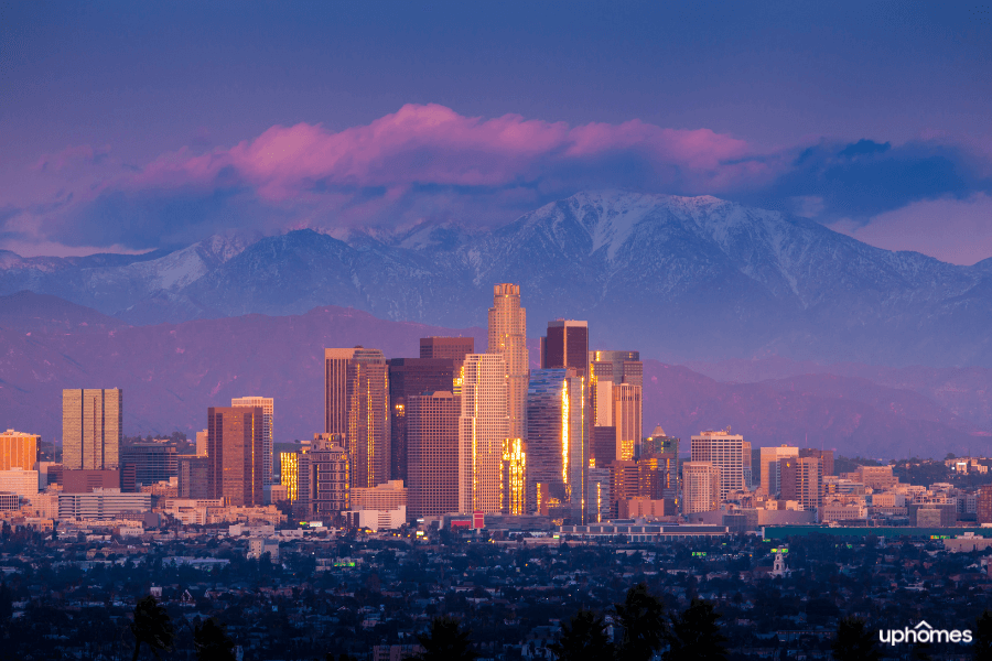 A photo of Los Angeles with the mountains in the background at sunset