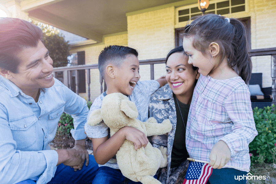 Beautiful Military Family in front of their home with mom returning from service while children are happy to welcome her home.