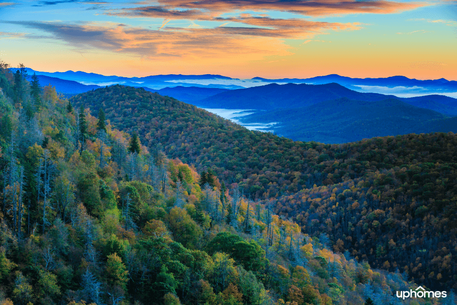 A photo of the mountains in Asheville NC with the sun setting and a beautiful skyline