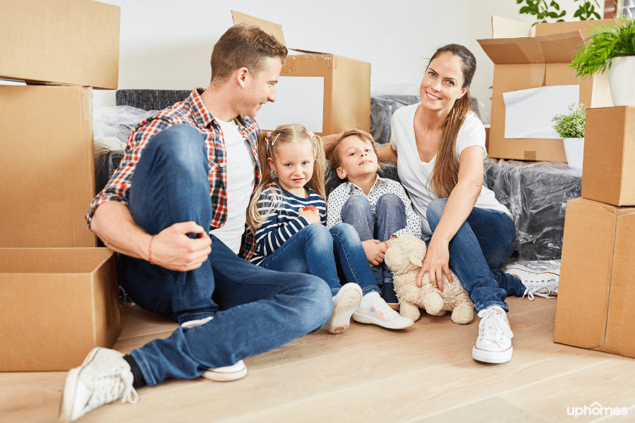 Moving boxes with a family and children with a boy and girl who are preparing to move to a new home