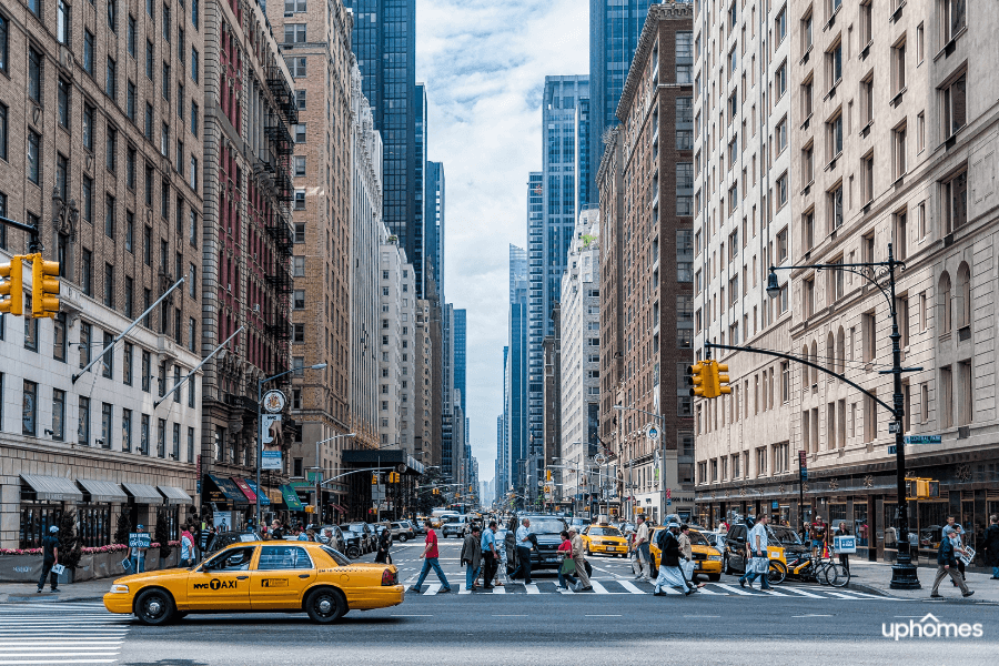 New York City streets and buildings with a yellow taxi cab and people walking by in the background in Manhattan