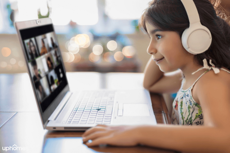 Learning at home with headphones on and a remote learning computer with an online meeting software