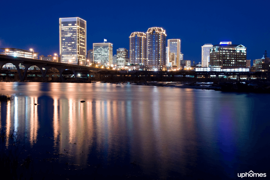 A photo of Richmond, VA with the water and downtown city buildings lit up