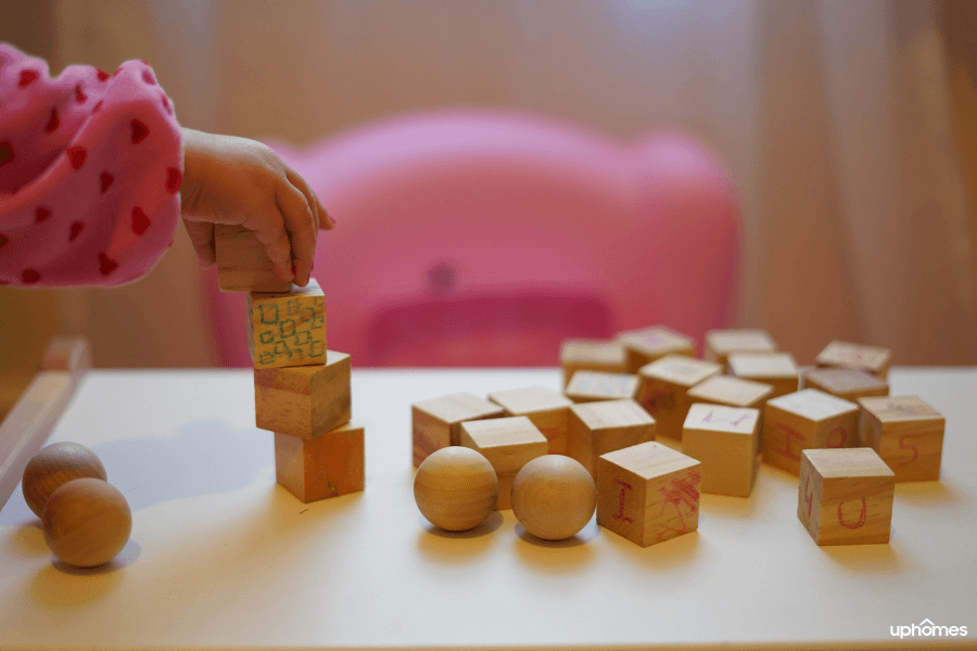 Image of child playing with blocks and stacking them on top of one another. Create a sensory room in your home that is safe and fun for all and a sensory-friendly environment for all