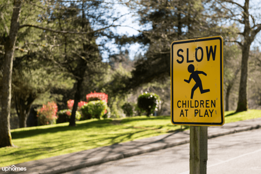 A bright yellow slow children at play sign that alerts the car drivers to pay attention to their speed in case they are driving to fast through a safe neighborhood