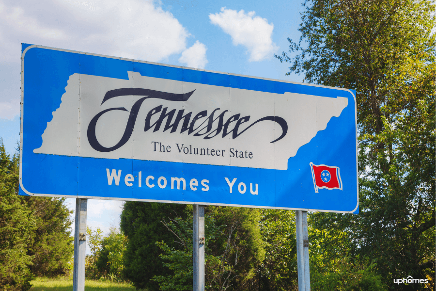 Welcome to Tennessee sign with a flag and nature in the background
