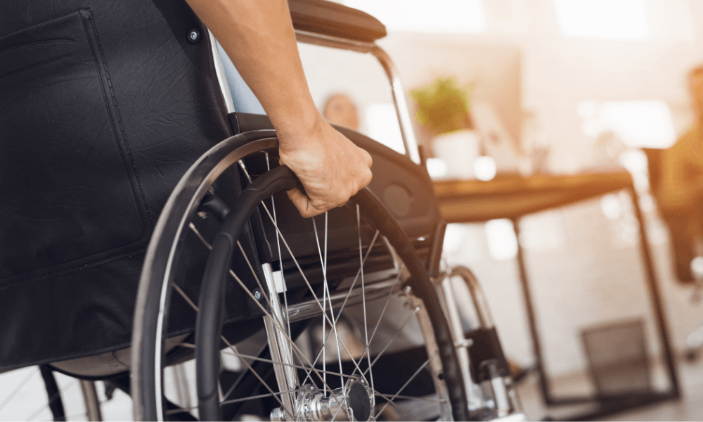 Closeup of wheelchair and people in background of photo