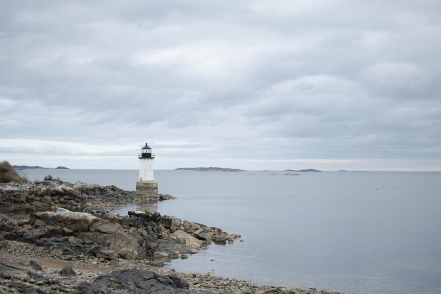 Salem, MA lighthouse on a cloudy day near the water and rocks