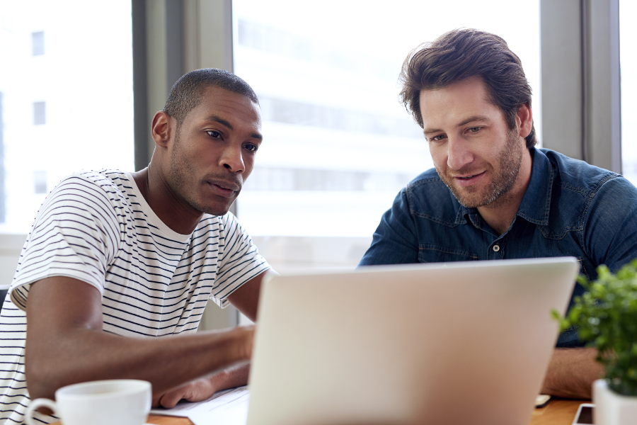 two people gathering around a laptop 