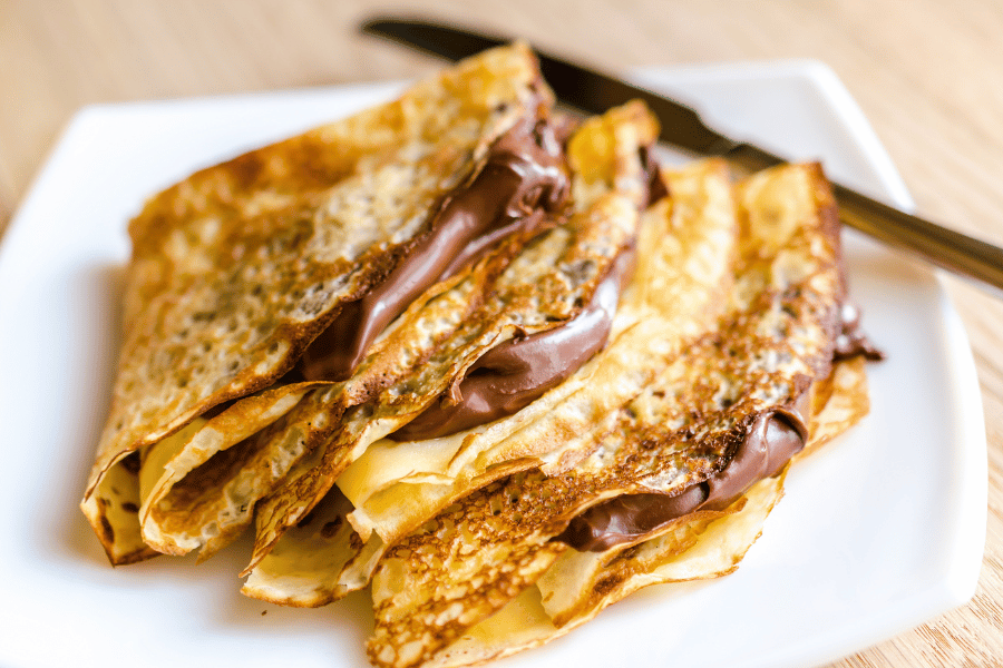 Fresh made Paris Bistro Crepes with nutella on a white plate 