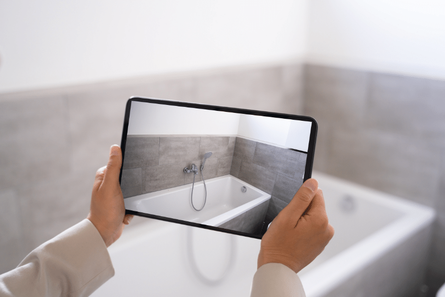 Virtual tour on a tablet in a bathroom with a white tub and tile 