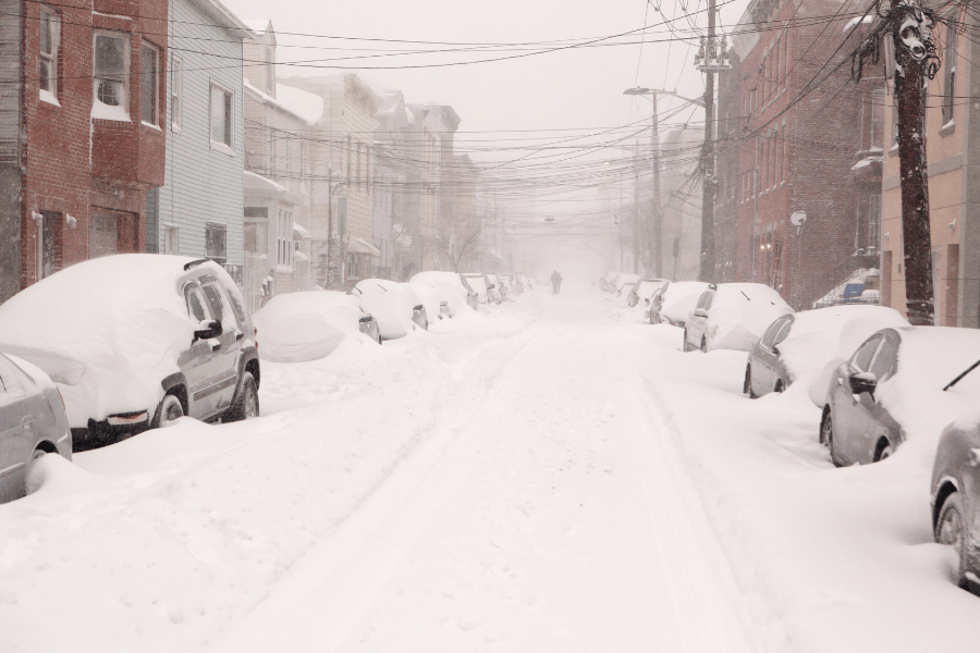 Image of a snowy street with cars on each side