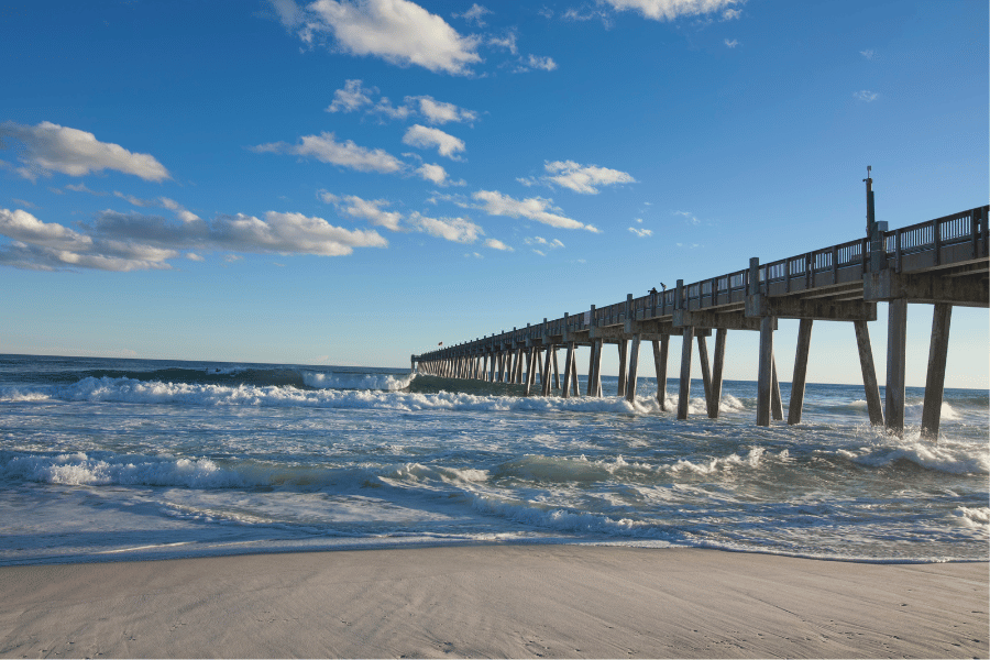 Pensacola Beach with a pier on a sunny day 