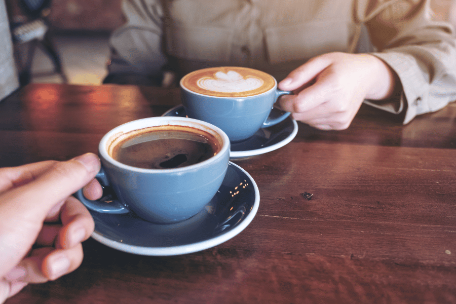 friends drinking cups of coffee together at a coffee shop