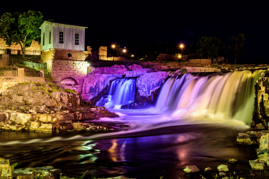 Falls Park in South Dakota at night with waterfall and purple lights