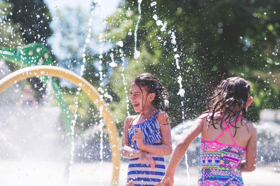 Kids playing in a splash pad on a warm and sunny day