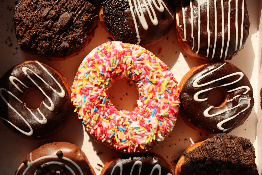 Donuts in a box with sprinkles and chocolate icing