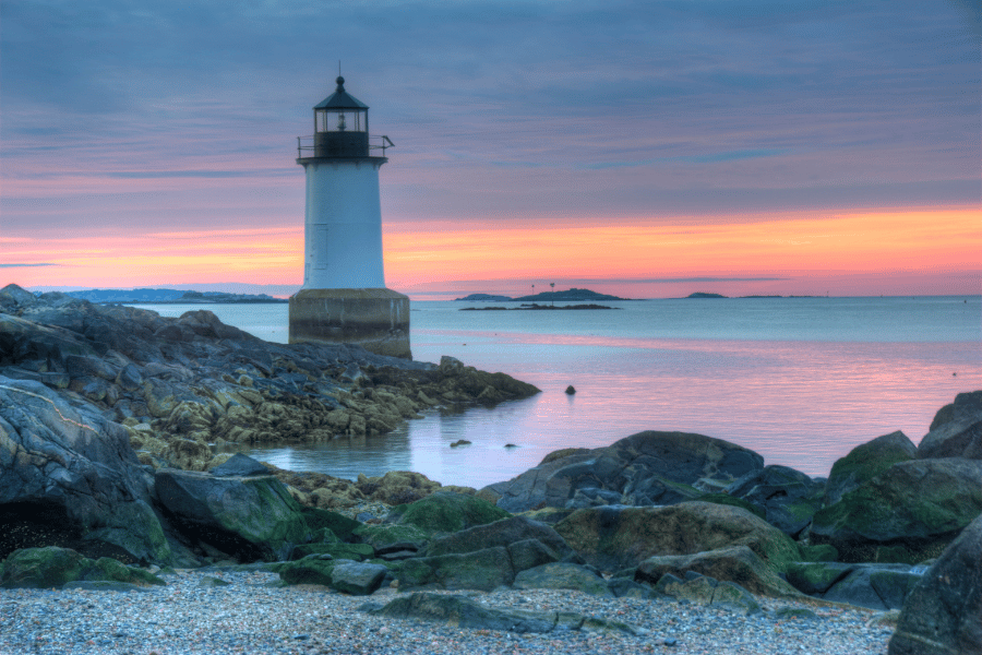Fort Pickering Lighthouse near the rocks and water during sunset 