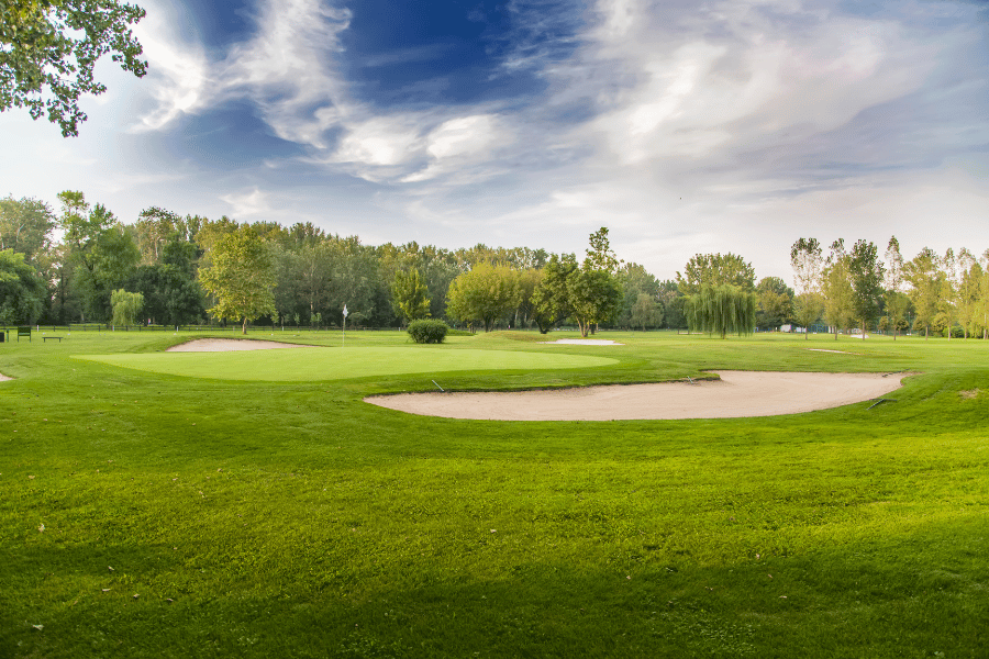 Golf Course in Summer with green trees and sand pits 