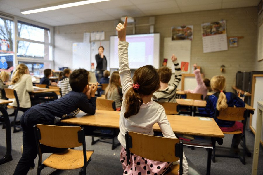 kids in class raising their hands 