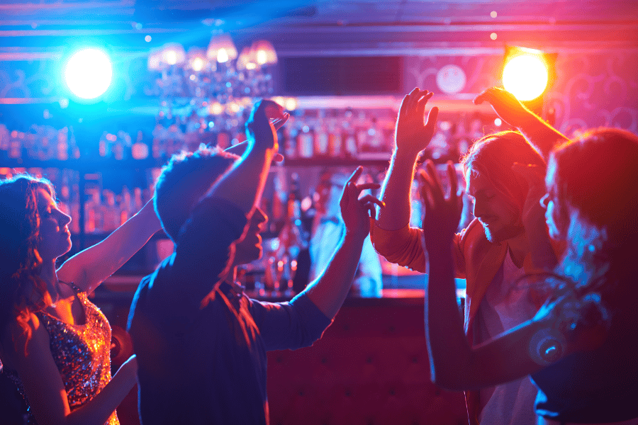Photo of four young adults dancing at a bar