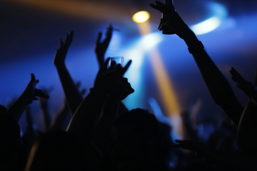 Dancing in a nightclub party with blue lights and drinks