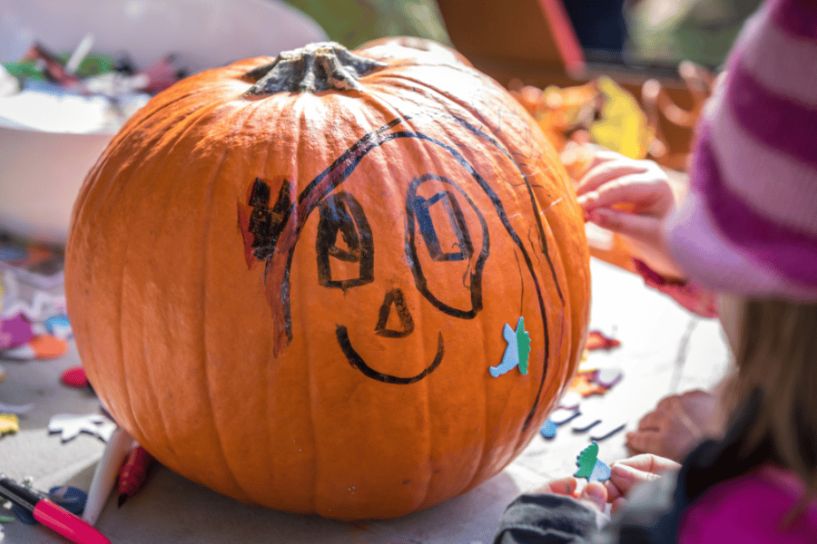 decorating a pumpkin with marker and stickers 