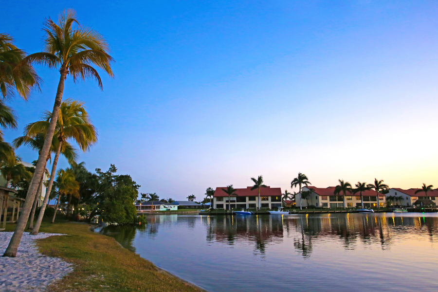 Waters Edge in Cape Coral, FL during sunset with palm trees and houses