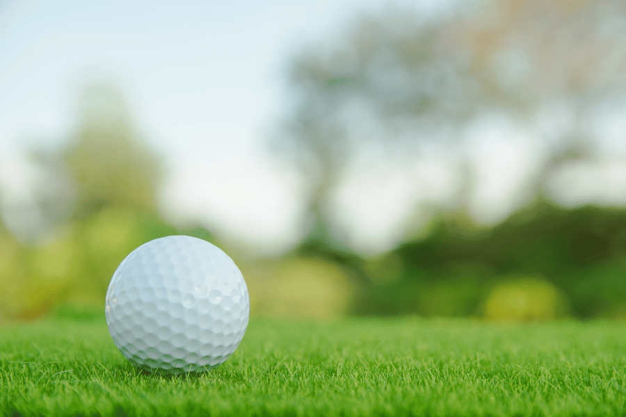 Close up of golf ball sitting on a golf course green fairway