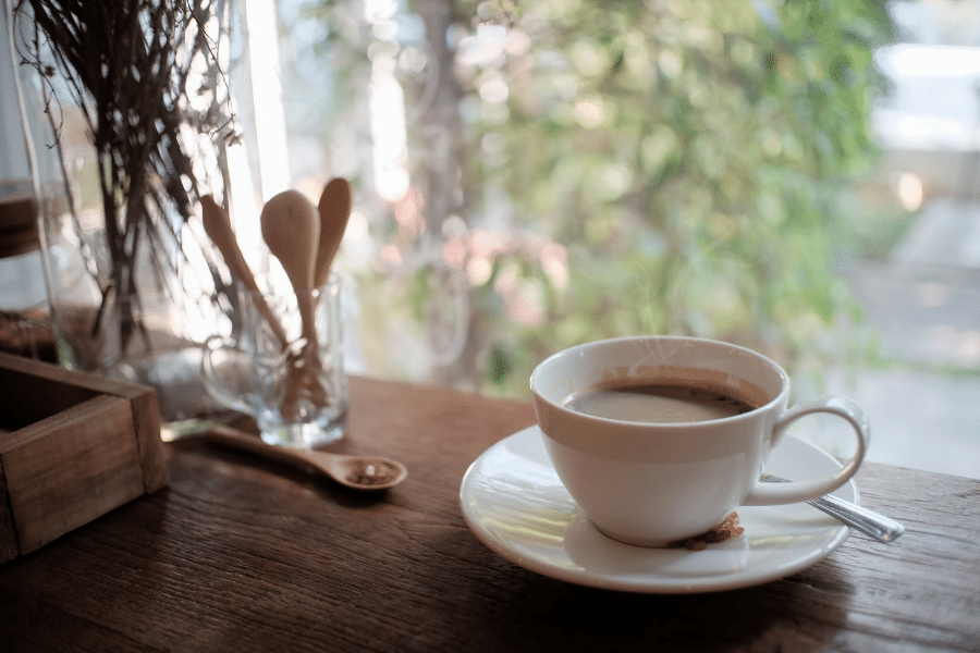 Cup of coffee on a wood table with wood spoons 