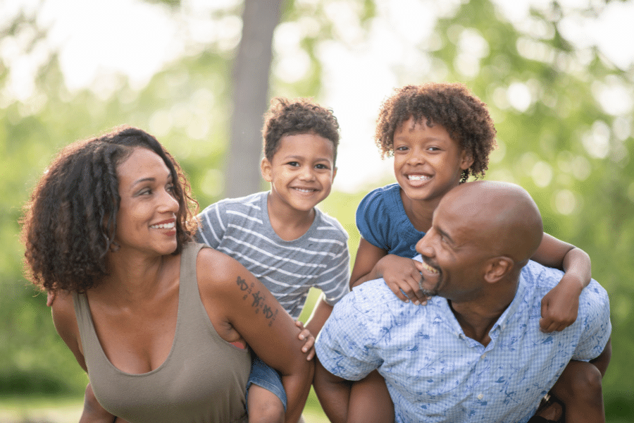 Two parents and two kids having a good time on a warm and sunny day outside