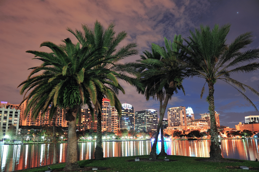View of downtown Orlando with Palm Trees at sunset and a lake