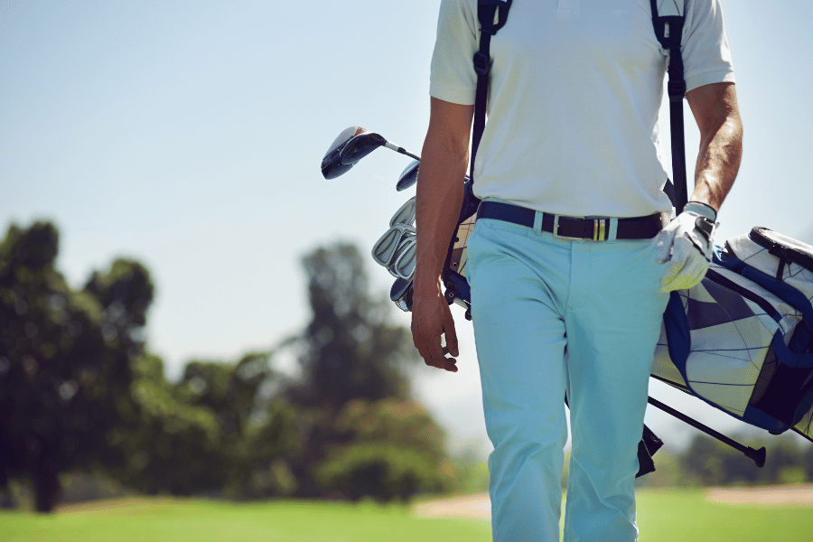 Walkable Golf Course man holding golf bag with blue pants