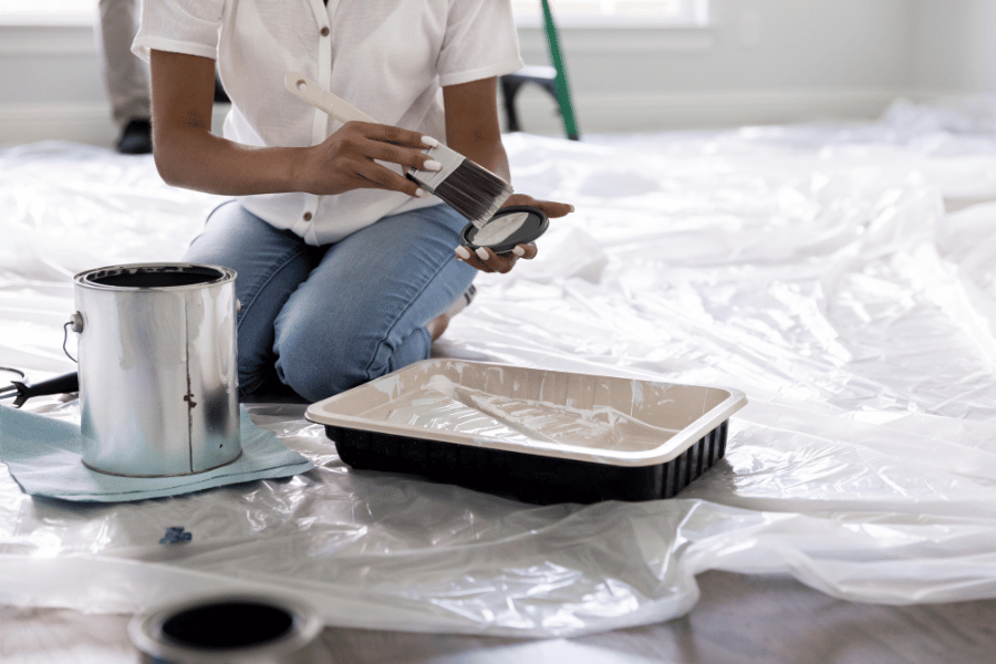 Opening a paint can getting ready to paint a house