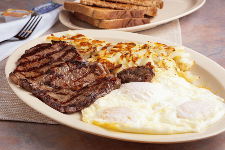 steak and eggs on table