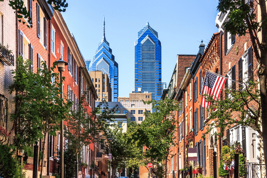 Philadelphia row houses lining the street with downtown buildings in the background