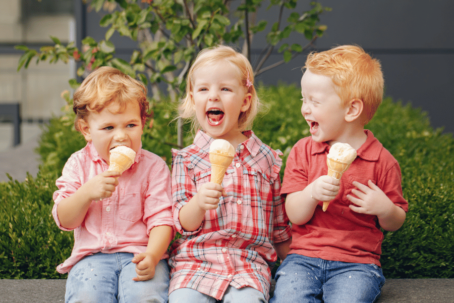 Image of three children laughing and holding ice cream