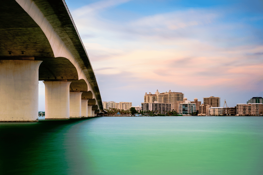 Blue green water in Sarasota Bay with buildings and bridge  