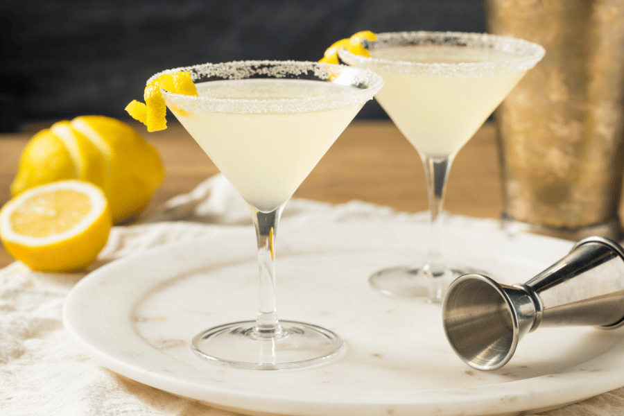 Two lemon drop martinis with lemons in chilled glasses