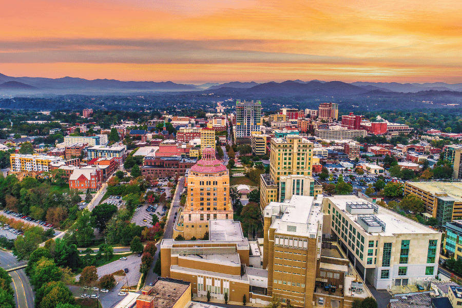 city view of Asheville, NC with orange sky in the distance