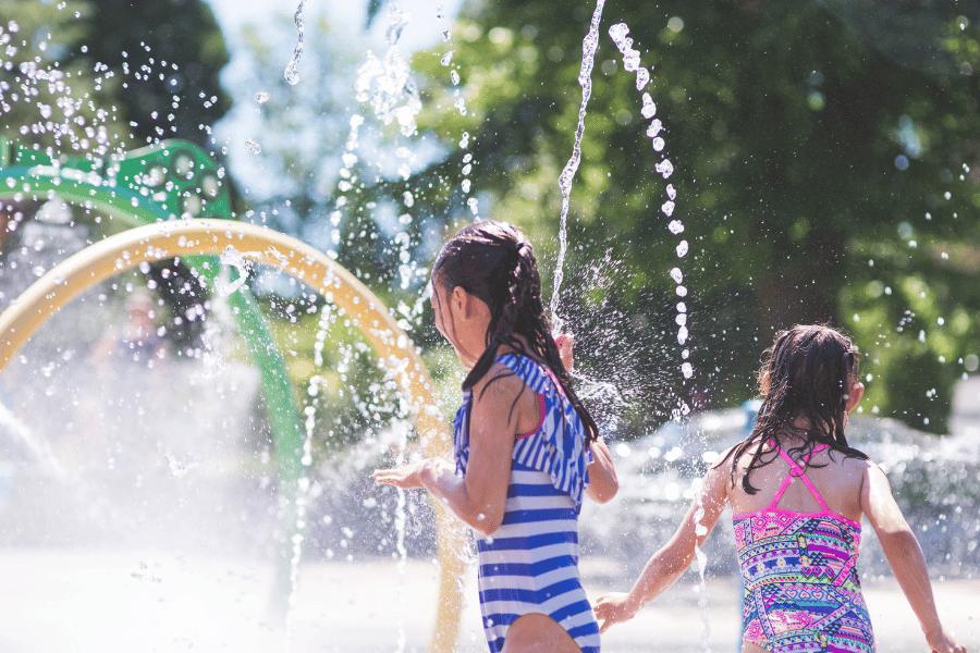 children playing in splash pad with sprinklers 
