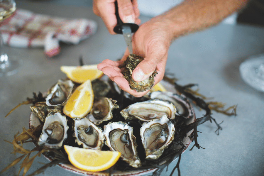 shucking oysters with a knife and lemon